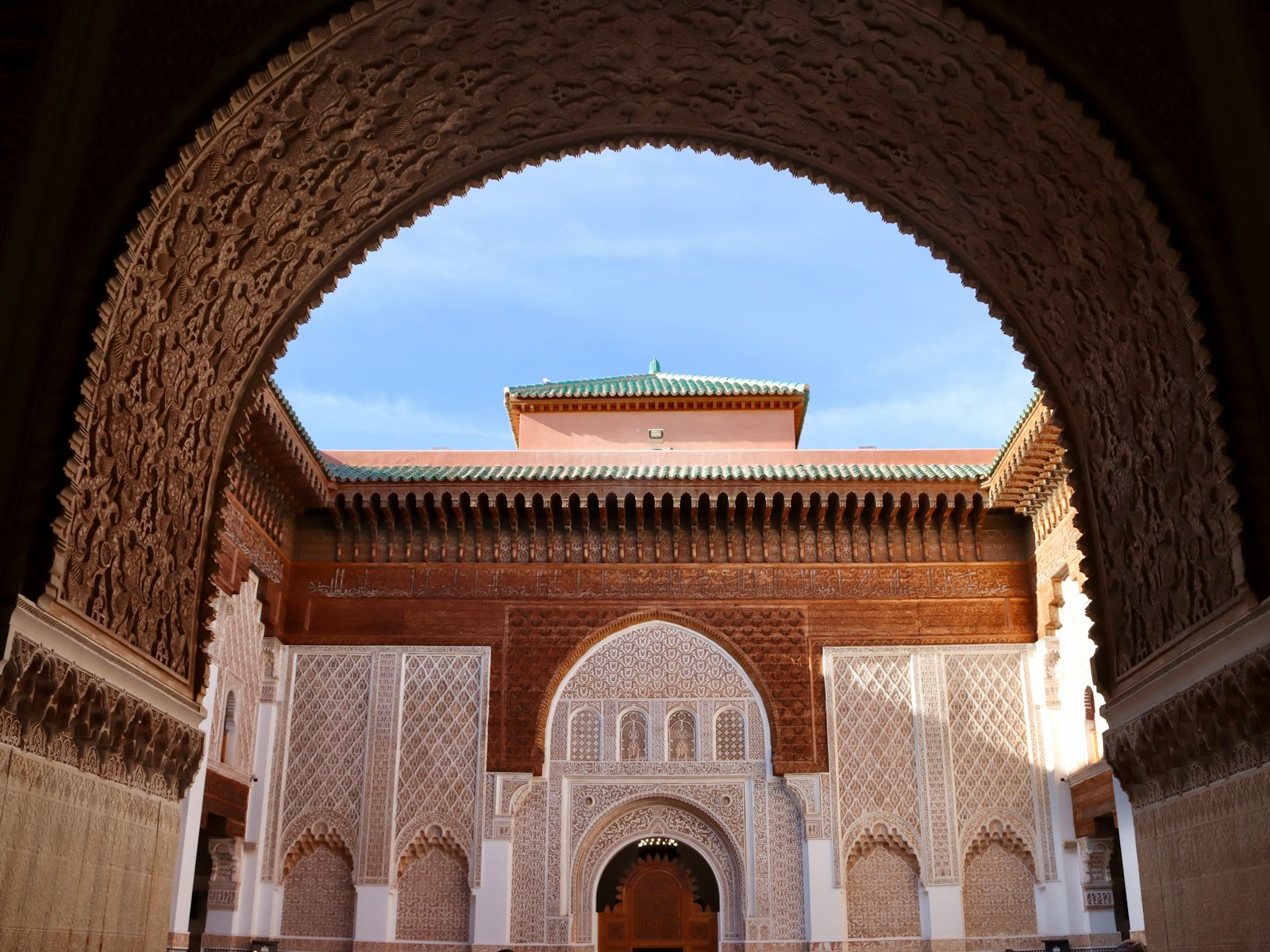 A building with a doorway and a clock tower in the background