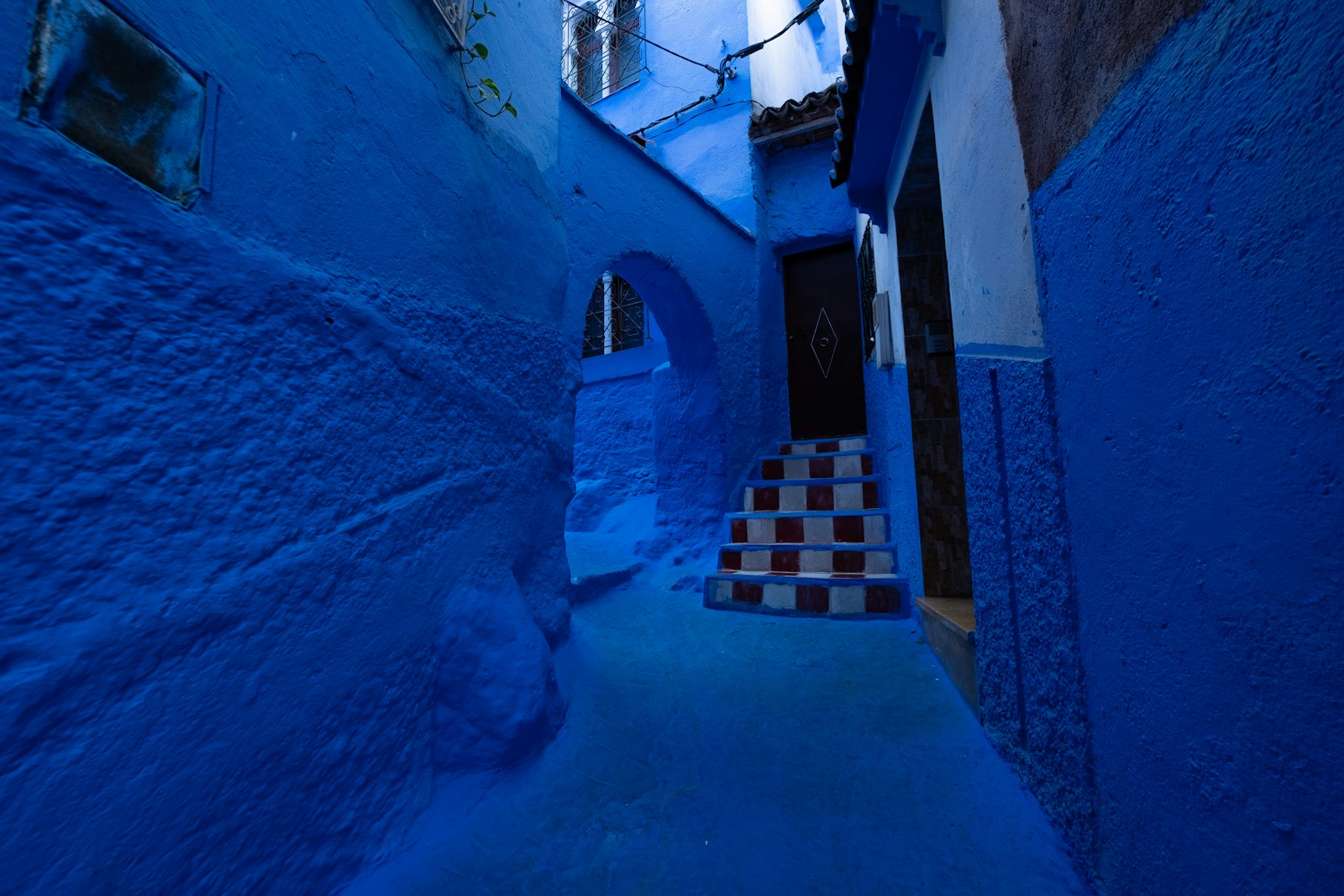 Narrow alleyway painted in vibrant blue hues