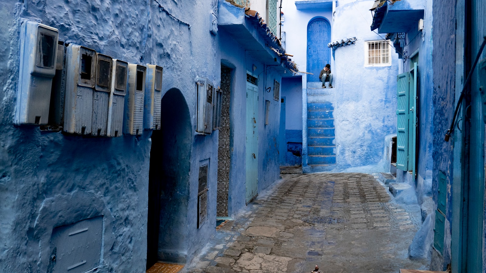 pathway between blue concrete building