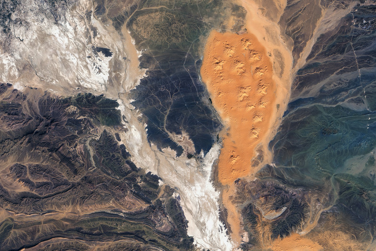 Aerial view of a desert landscape with sand dunes.