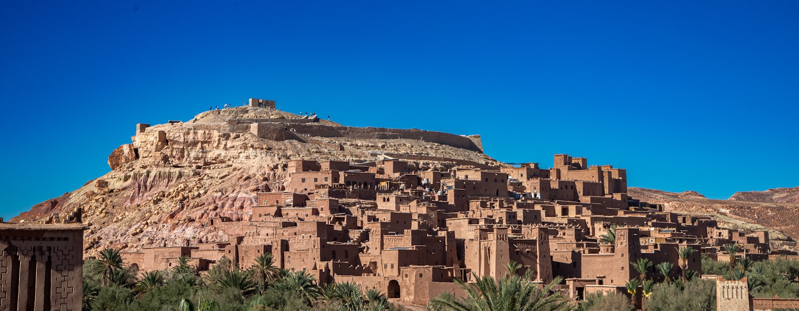 Ancient clay buildings on a hillside under blue sky
