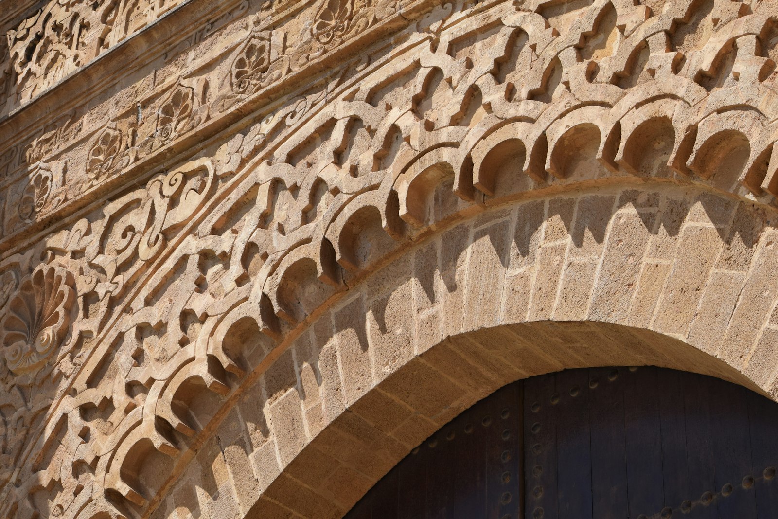 Intricate stone carvings above an arched doorway