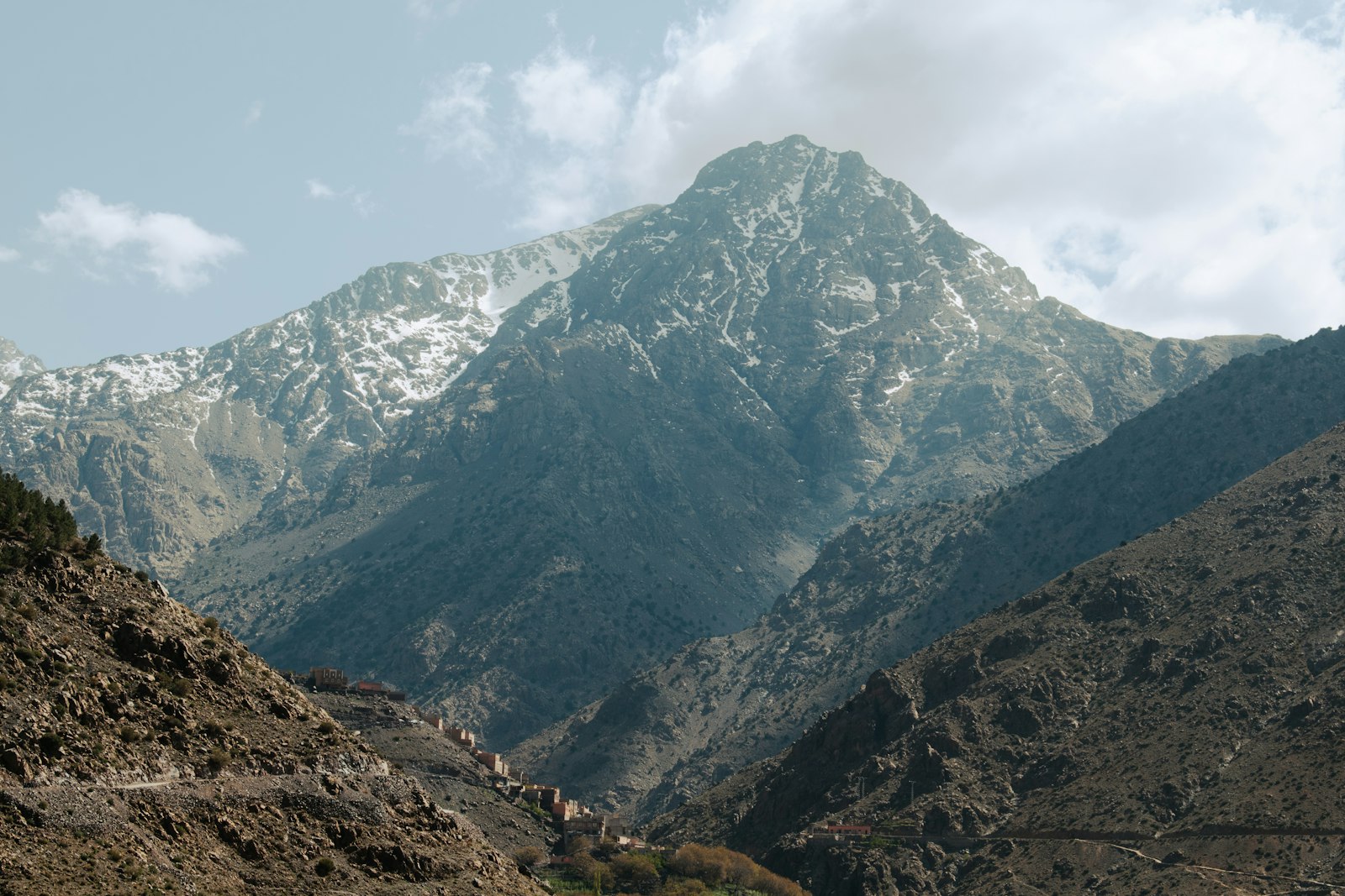 A snow-capped mountain rises amidst the peaks.