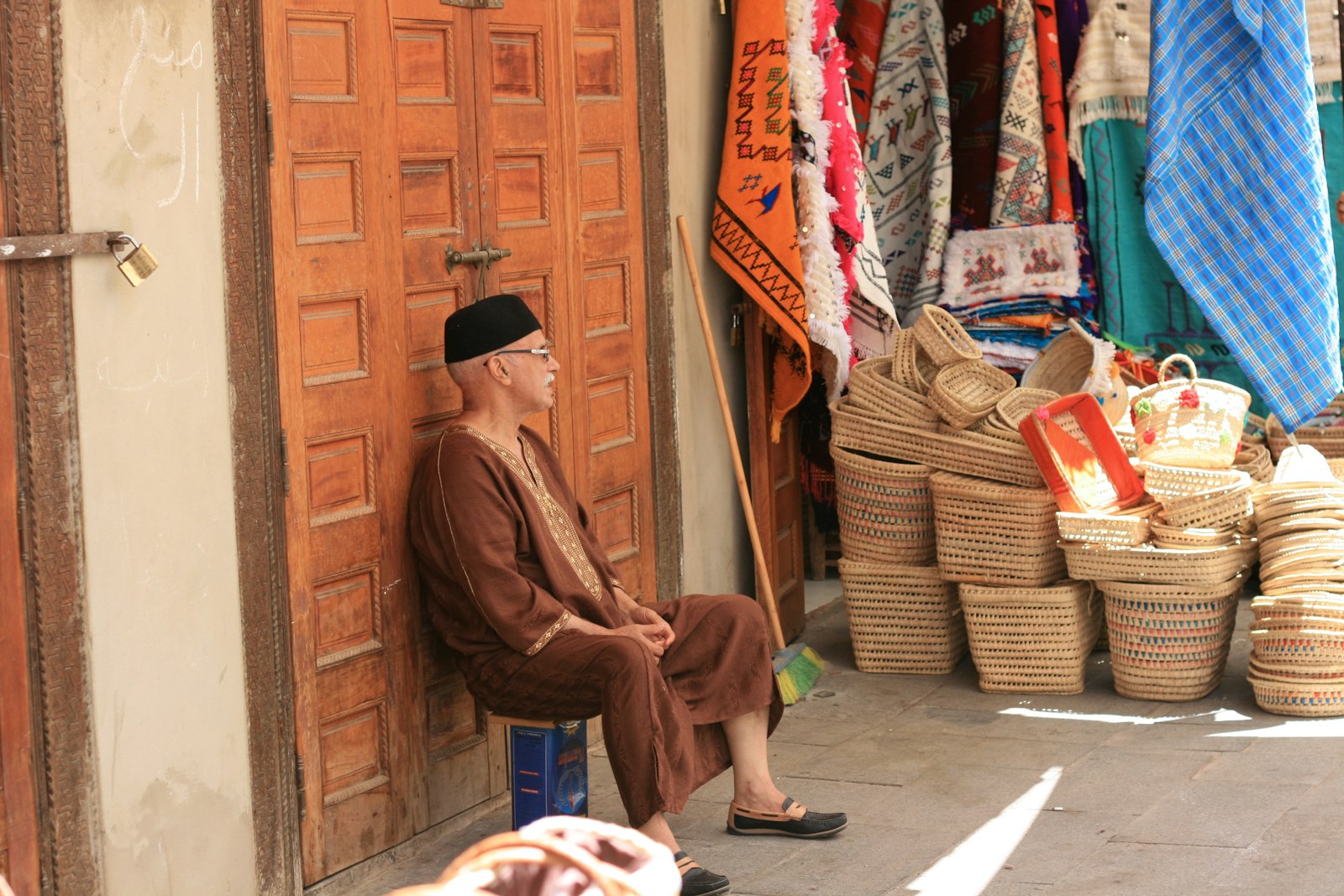 man in brown long sleeve shirt and black hat sitting on floor