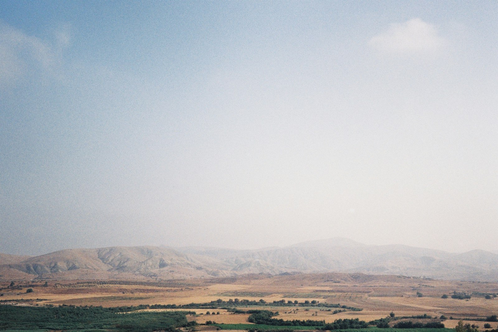 A view of a field and mountains in the distance