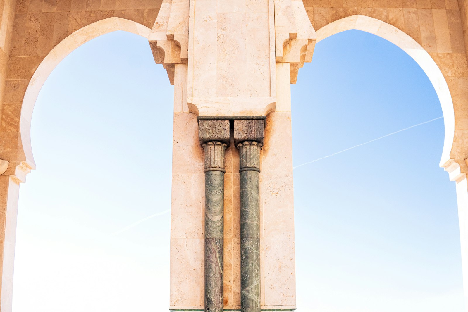 A person sitting on a bench in front of an arch