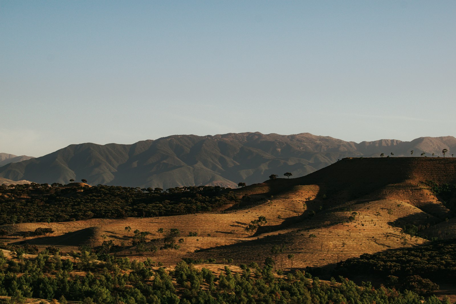 Hills and mountains under a clear blue sky.