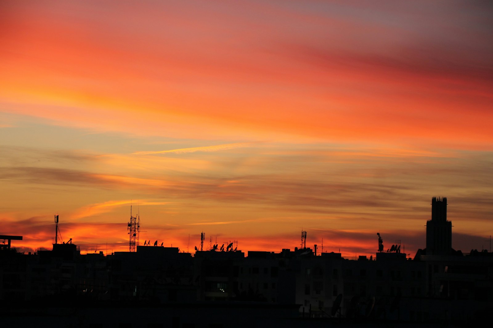 a sunset view of a city with tall buildings