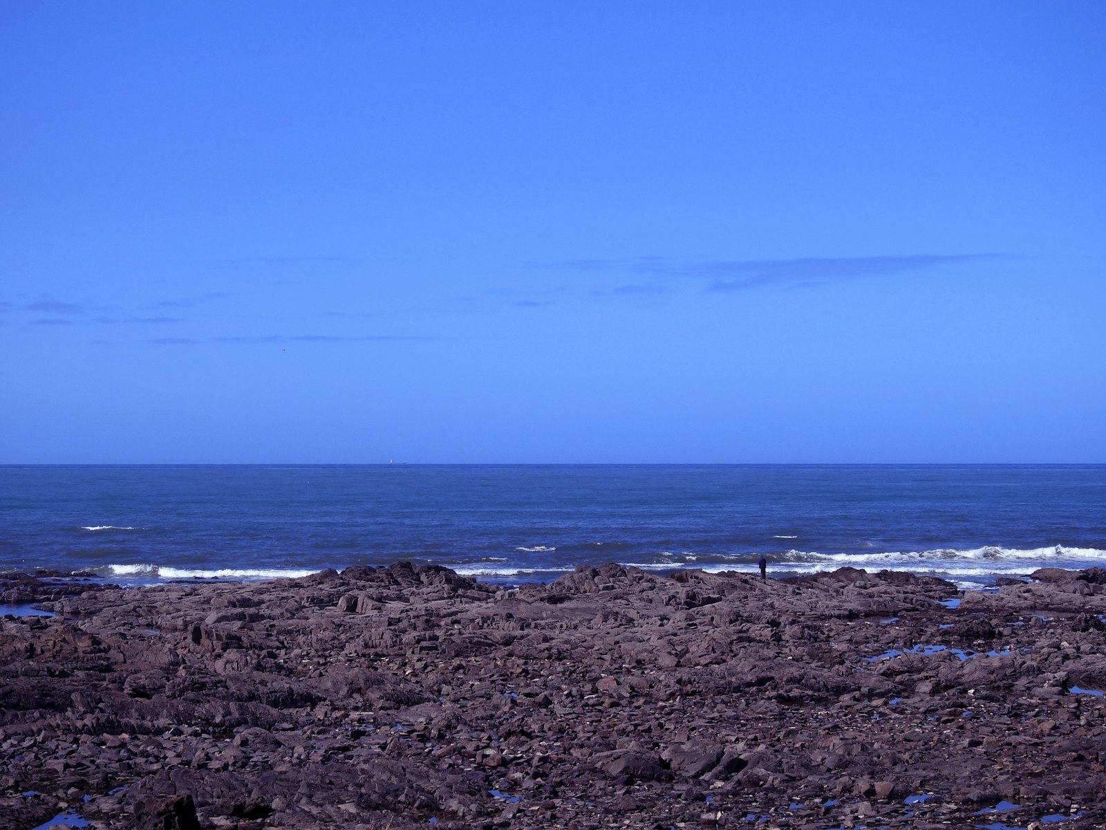 a man riding a surfboard on top of a rocky beach
