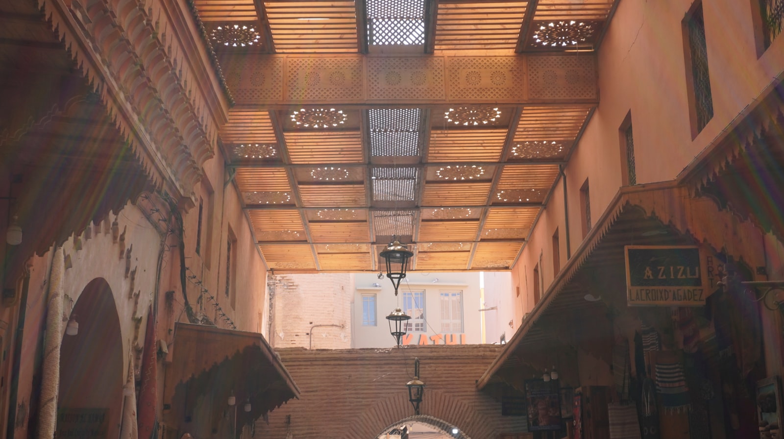 Ornate wooden ceiling with geometric patterns in a marketplace.