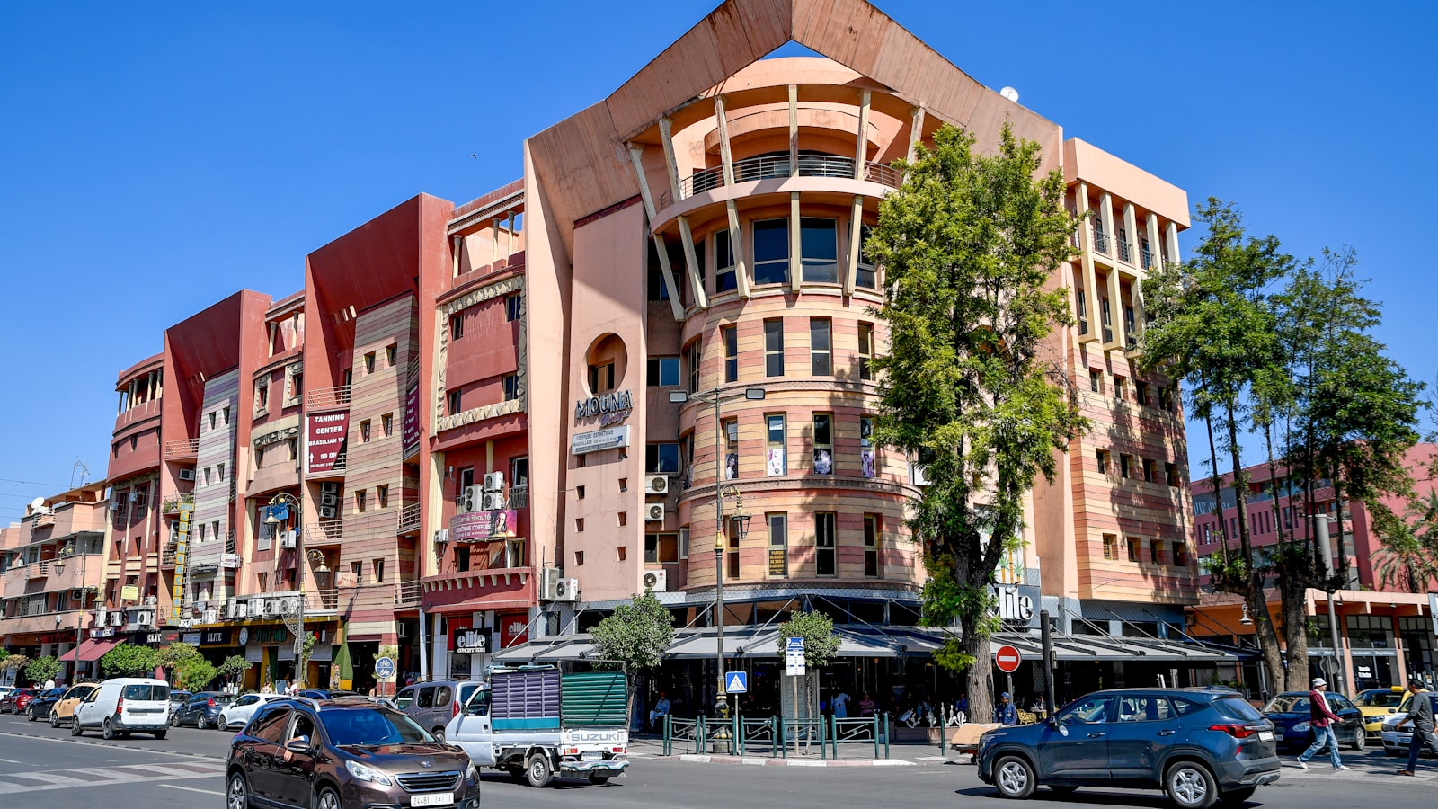 Modern buildings line a busy street with cars.