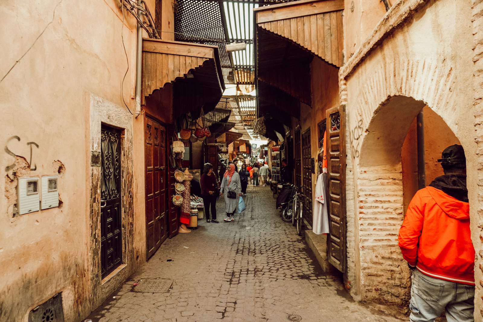 a group of people walking down a narrow alley way