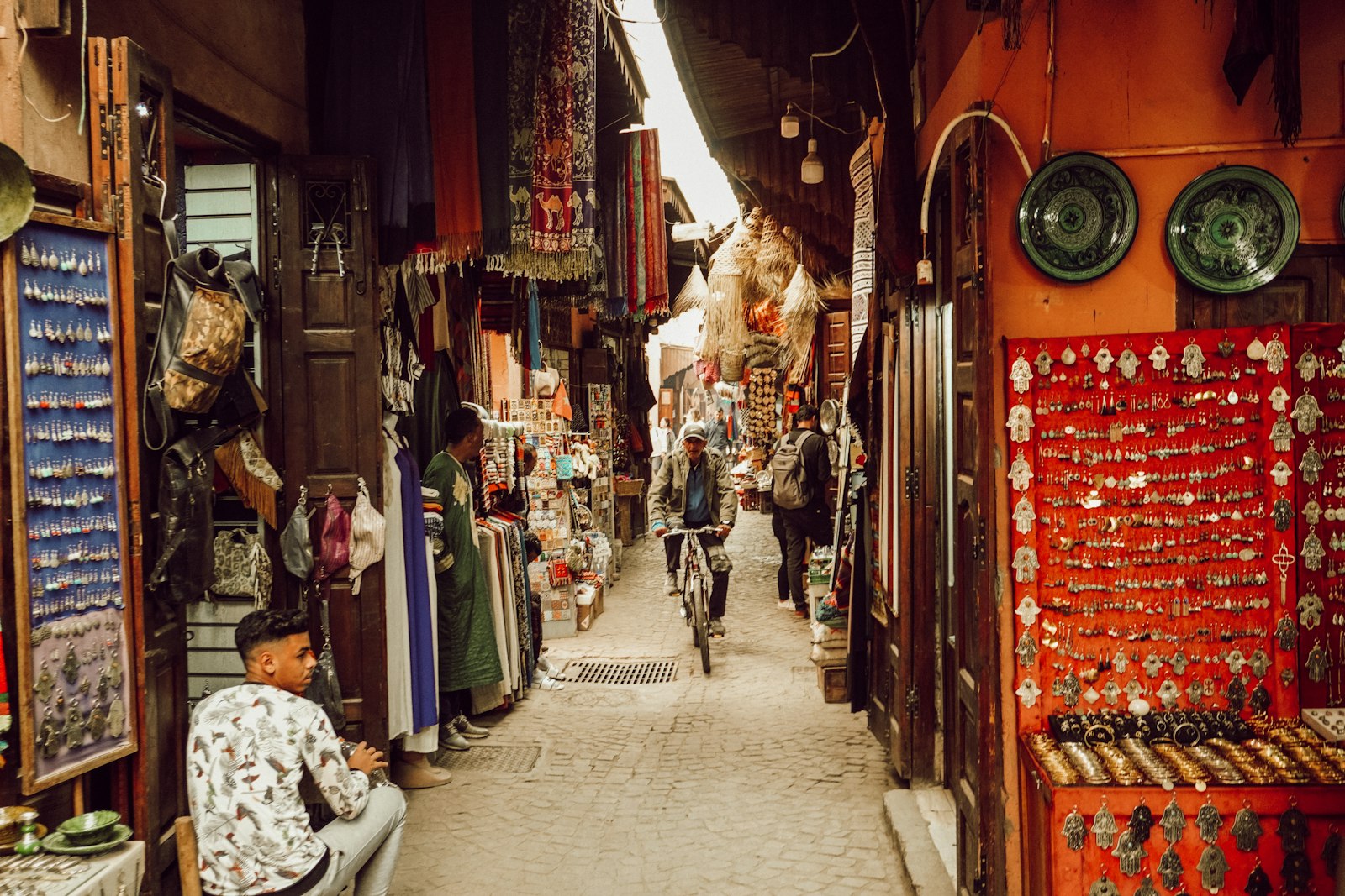 a man riding a bike down a narrow alley way