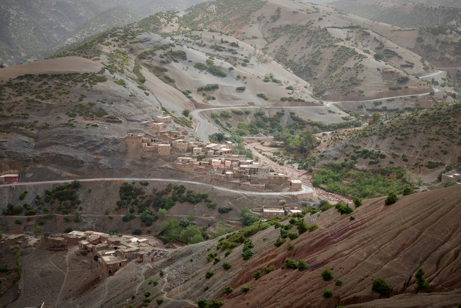 a landscape with a dirt road and buildings